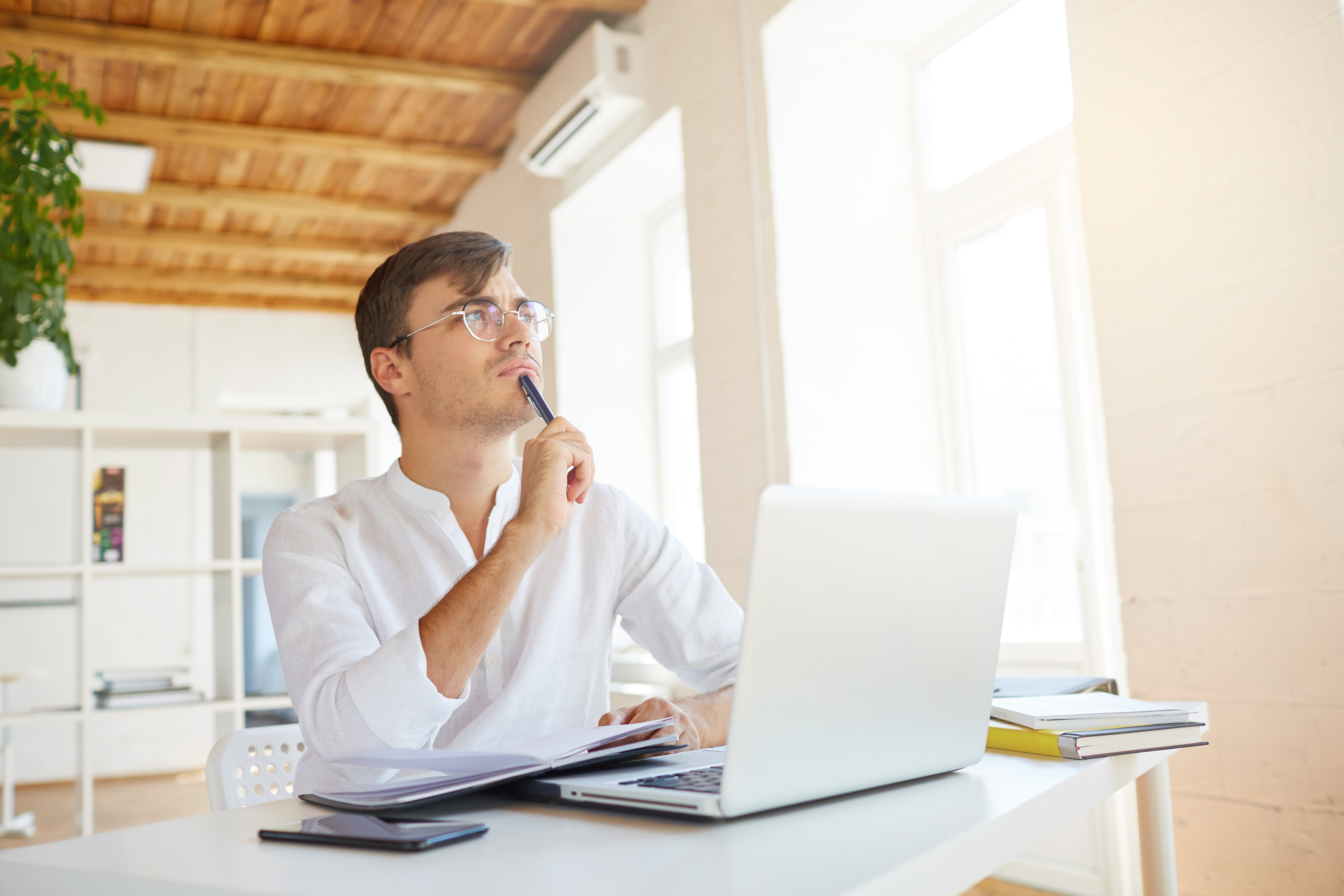 indoor-shot-thoughtful-concentrated-young-businessman-wears-white-shirt-office